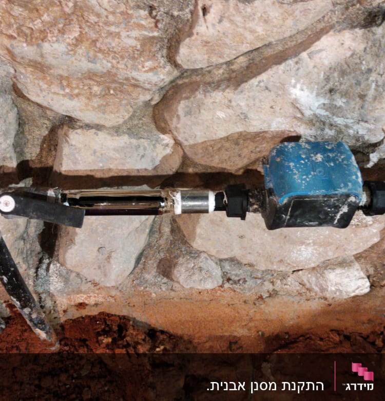 צינורות מים עם שסתום וברז על קיר אבן